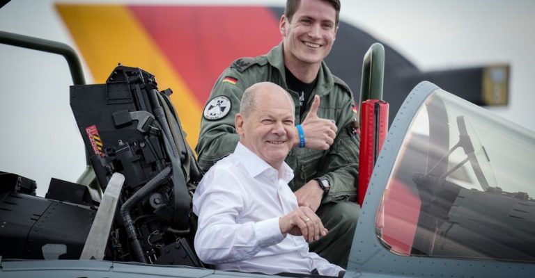 16.06.2023, Schleswig-Holstein, Jagel: Bundeskanzler Olaf Scholz (SPD, vorne) steigt neben dem Piloten Steven R. in das Cockpit eines Kampfflugzeugs vom Typ Eurofighter der Luftwaffe bei seinem Besuch des internationalen Luftwaffen-Manövers «Air Defender 2023» auf dem Luftwaffenstützpunkt Jagel. An der Luftwaffenübung unter deutscher Führung nehmen bis zum 23. Juni 25 Nationen sowie die Nato teil. Nach Angaben der Bundeswehr sind rund 10 000 Soldatinnen und Soldaten und 250 Flugzeuge beteiligt. Foto: Kay Nietfeld/dpa +++ dpa-Bildfunk +++